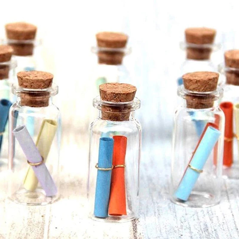 Glass cork stoppers with colorful wooden and plastic tubes displayed on a light blue background.