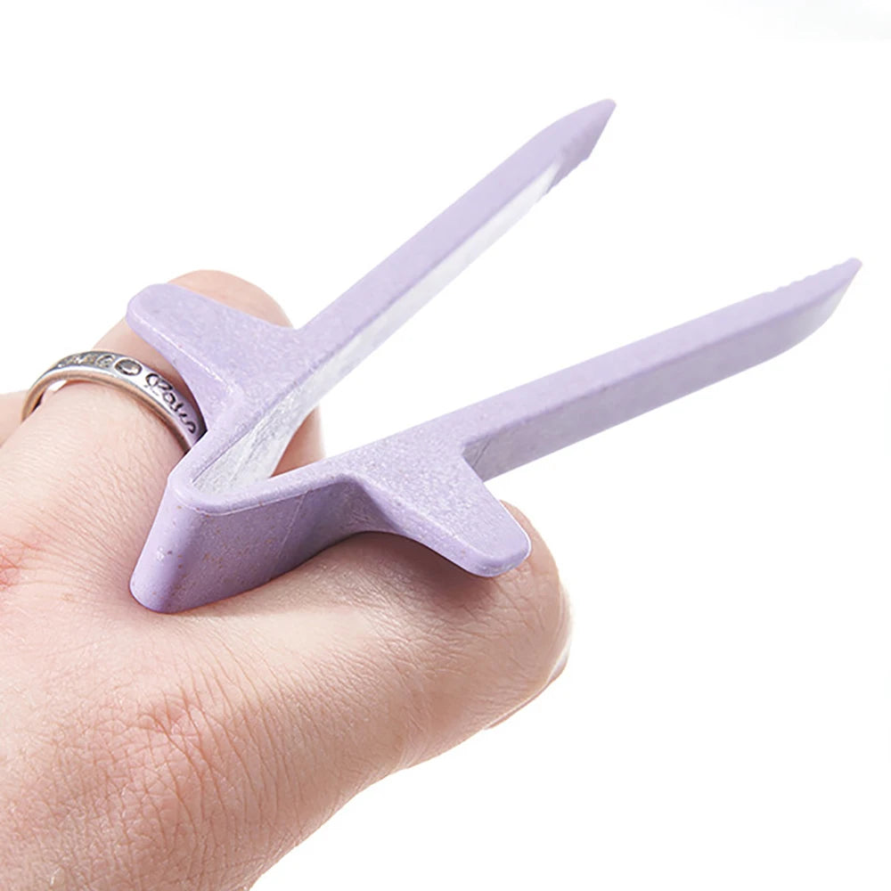 A hand holds a purple reusable wheat straw finger chopstick designed for clean snacking.