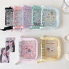 A collection of clear plastic card binders in various pastel colors and glitter designs for storing collectibles.