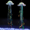 Iridescent mermaid and jellyfish party streamers hanging against a dark background over blue glitter.