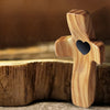 A wooden comfort prayer cross is placed in a shallow bowl, suggesting a product for anxiety relief.