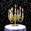 A golden candelabra holds nine white candles on a white cake stand against a dark background of stars.