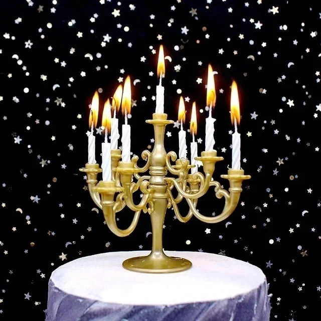 A golden candelabra holds nine white candles on a white cake stand against a dark background of stars.