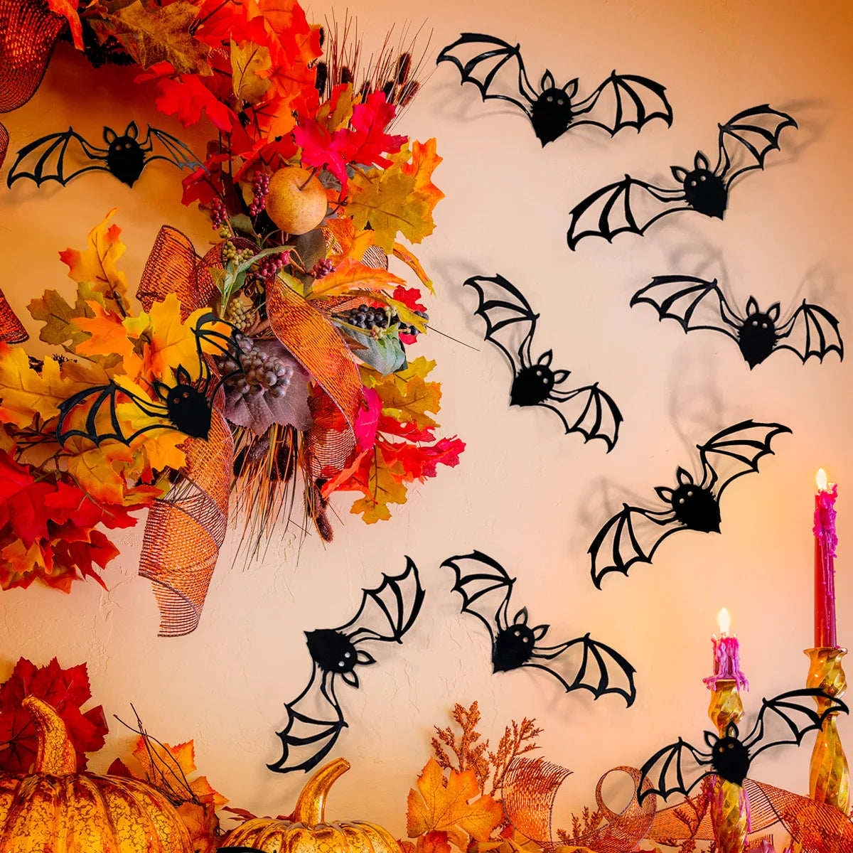 A wall decorated with black bat silhouettes made of autumn leaves and foliage.