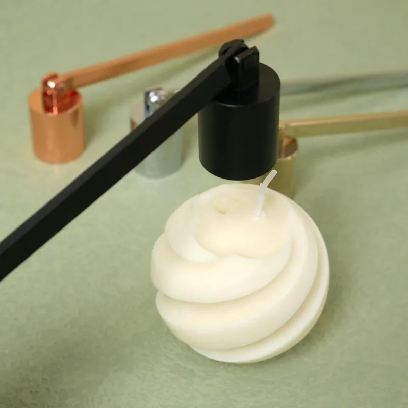 A stainless steel tool is used to extinguish a white candle flame.