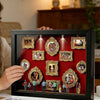 A black display case featuring framed photos and figurines illuminated by an LED light.