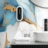 A modern bathroom or kitchen wall featuring blue marble texture with gold veining and a black sensor light fixture.