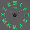 A gray wall clock face with green Roman numerals and black hands.