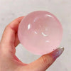 A hand holds a clear pink squishy toy shaped like a cat paw, showing its smooth surface.
