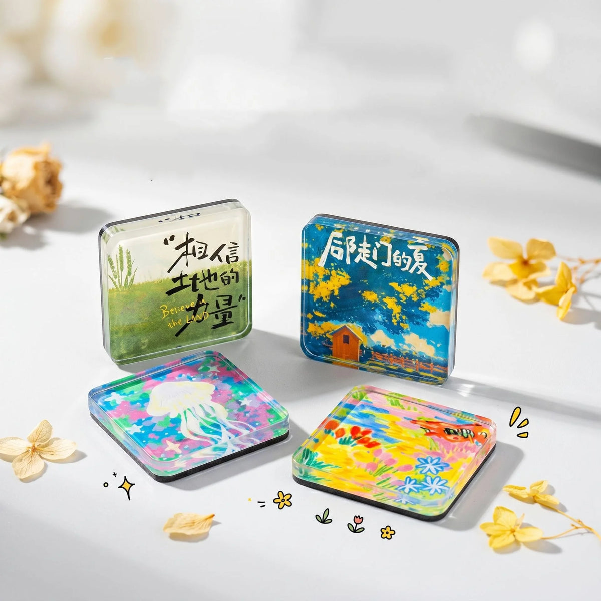 A collection of clear and colorful acrylic fridge magnets featuring nature scenes and Chinese text on a white surface.