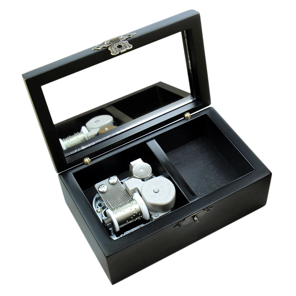 A black hand-cranked wooden music box with an open lid displaying the internal mechanism.