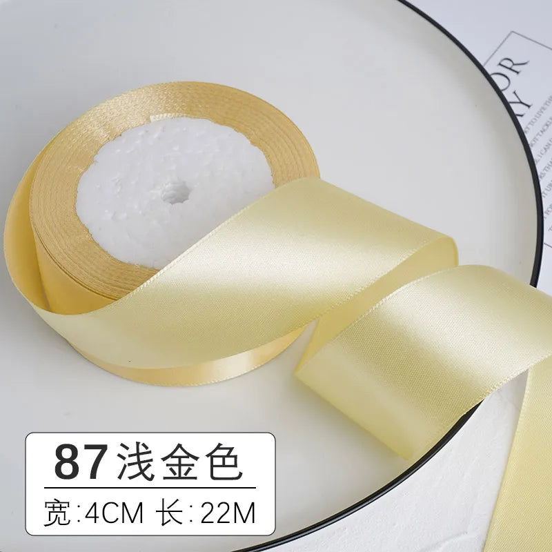 Un rouleau de ruban décoratif satin doré avec une insertion de mousse blanche sur une assiette blanche.