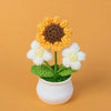 Handmade knitted sunflower with white petals and a brown center growing in a green pot