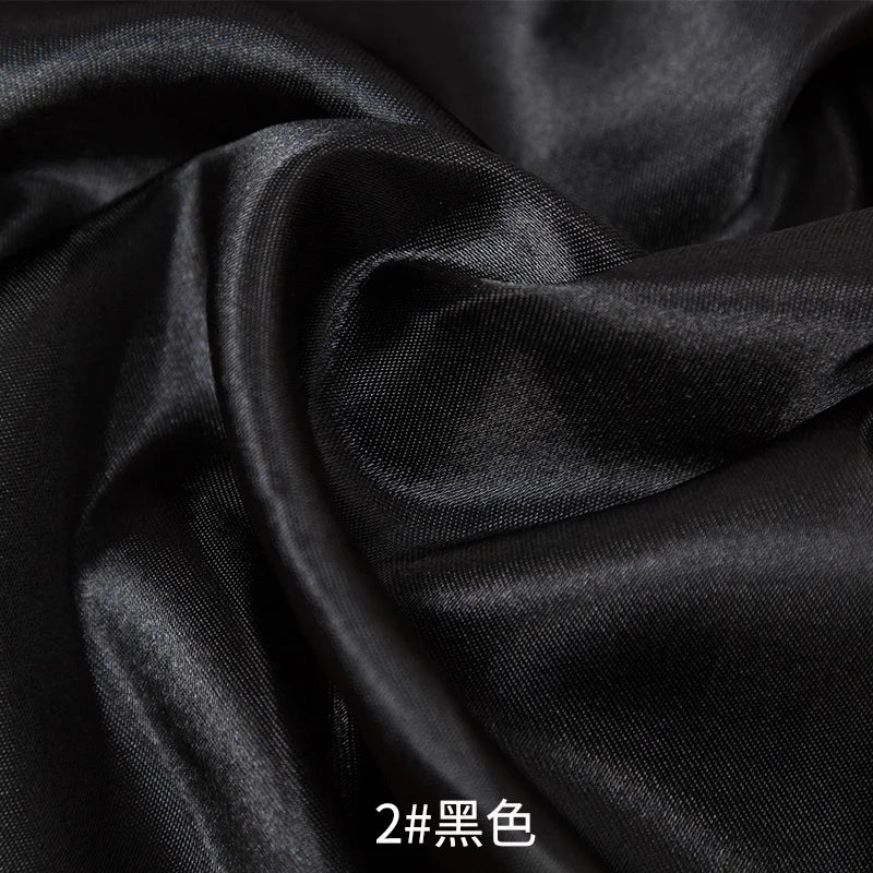 Black satin fabric draped and folded for sewing or DIY projects