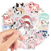 A hand is holding several cute pink cow cartoon decals for DIY decoration on a light background.