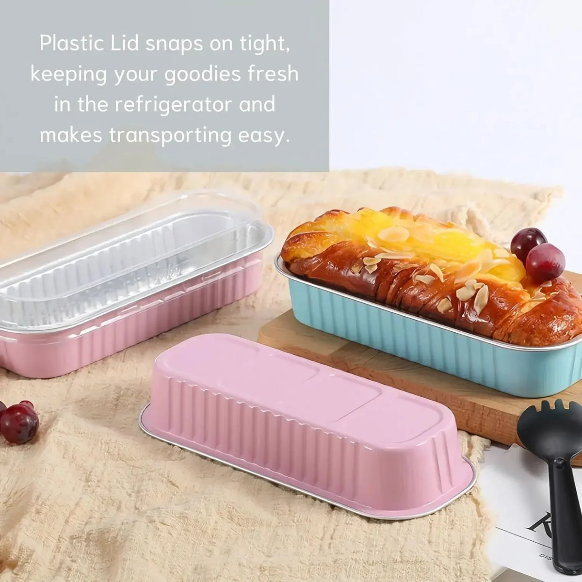 Pink and blue plastic rectangular food packaging containers with lids shown on a beige cloth.
