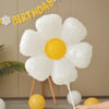 A white daisy-shaped balloon with a yellow center is displayed against a light background.