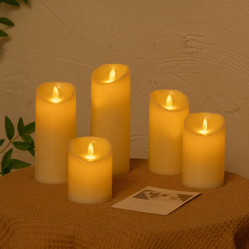 A grouping of glowing yellow LED candles on a tan cloth surface.