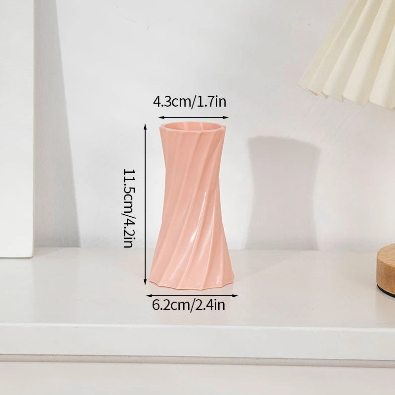 Eine hohe, rosa, fluitige Plastikblumenvase vor weißem Hintergrund.