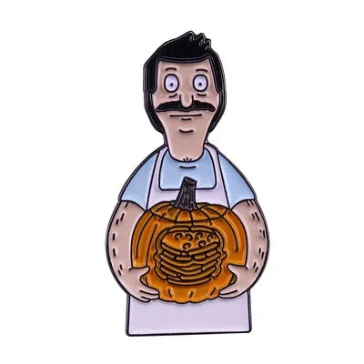 An enamel pin badge depicting a man with a mustache wearing an apron and holding a carved pumpkin.