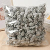 Bolsa de decoraciones de espuma de rosa gris artificial en empaque de plástico transparente.