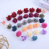 Collection de petites fleurs d'hydrangea artificielles dans diverses nuances de rouge, rose, violet et vert.