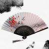 A vintage bamboo folding hand fan with pink and gray stripes, featuring red leaves and birds.