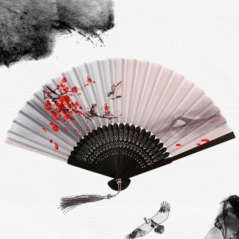 A vintage bamboo folding hand fan with pink and gray stripes, featuring red leaves and birds.