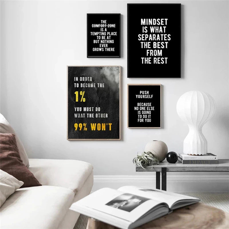 A gallery wall featuring three black and white inspirational quotes on a white wall above a wooden table.