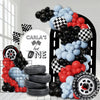 A balloon arch set featuring black and red balloons and stacked tires with a racing theme.