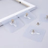 Transparent self-adhesive wall hooks for pictures and frames displayed on a white surface.