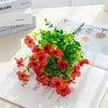 A bouquet of artificial flowers featuring vibrant orange-red eucalyptus leaves and small violet blossoms.