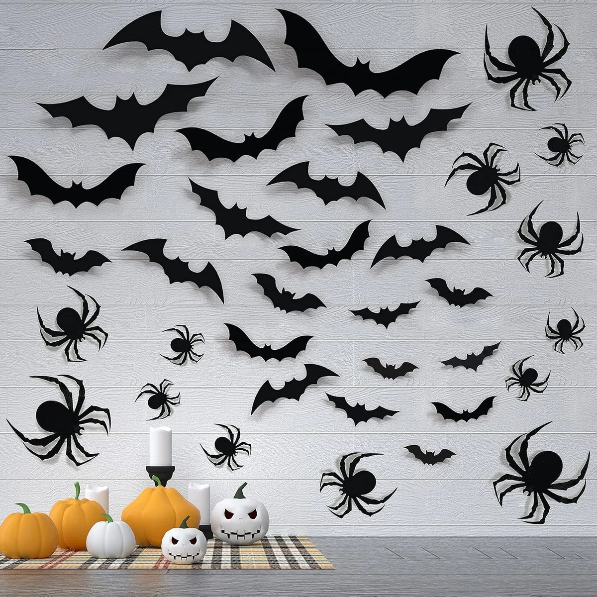 A collection of black bat silhouettes and spiders are displayed as wall stickers for Halloween décor.