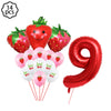 A kit of strawberry-themed party supplies including strawberries, balloons, and a red number nine foil balloon.