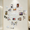 A wall collage featuring framed photos and leaves arranged in a family tree design.