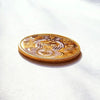 A round gold commemorative coin featuring the Eye of Providence design on a white background.