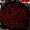 A bouquet of deep red glitter artificial roses displayed against a dark background.