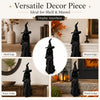 A black faceless witch figurine displayed on various surfaces including a shelf, mantel, entry table, and porch ledge.