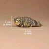A detailed brass alligator desk decor figurine measuring 6.7cm long and 2.1cm high.
