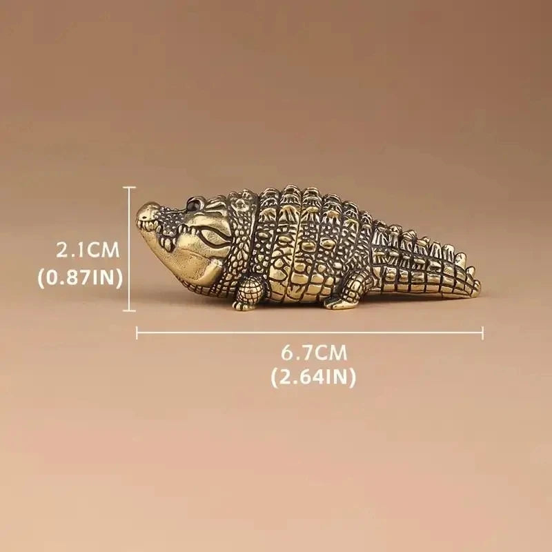 A detailed brass alligator desk decor figurine measuring 6.7cm long and 2.1cm high.