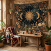 A rustic wooden table holds a vintage celestial sun and moon tapestry as a bohemian wall hanging in an earthy interior.