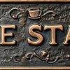 A vintage metal sign with the words COFFEE STATION embossed on it, featuring small teacup graphics.