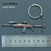 A miniature alloy gun model keychain with a realistic finish is shown next to a ruler.