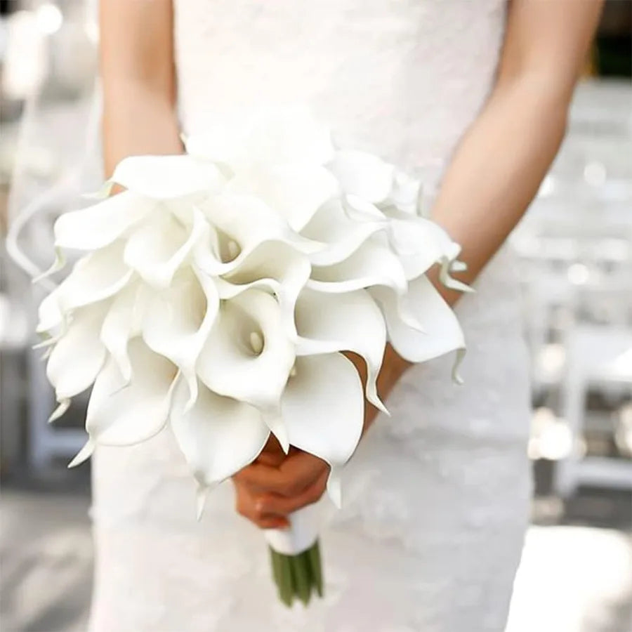 A person holds a bouquet of white calla lily stems for bouquets and decor.