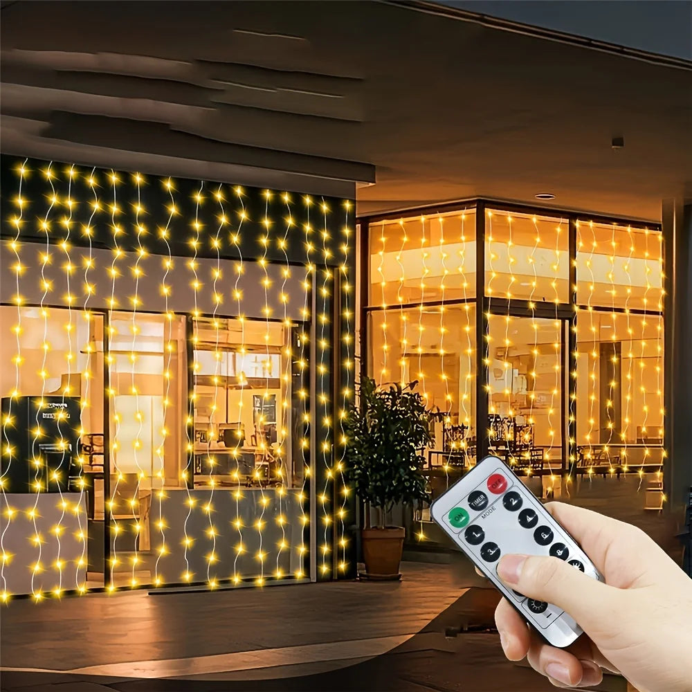 A hand holds a remote control for USB-powered fairy curtain string lights illuminating a storefront window.