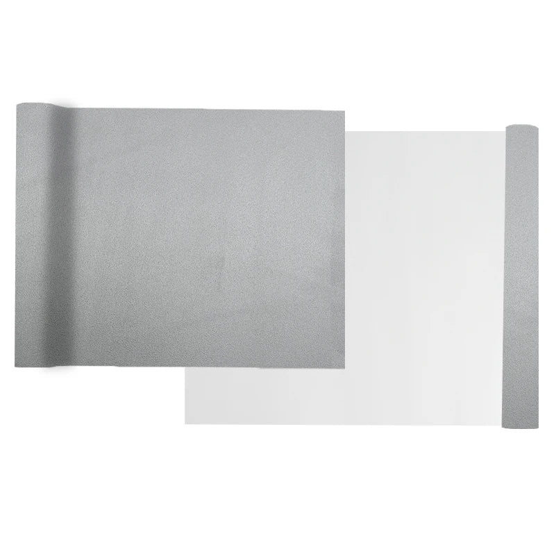 A sheet of gray self-adhesive suede wrap fabric shown next to its protective backing.