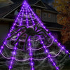 A giant purple spider web illuminated by lights, featuring a large black spider against a house backdrop.