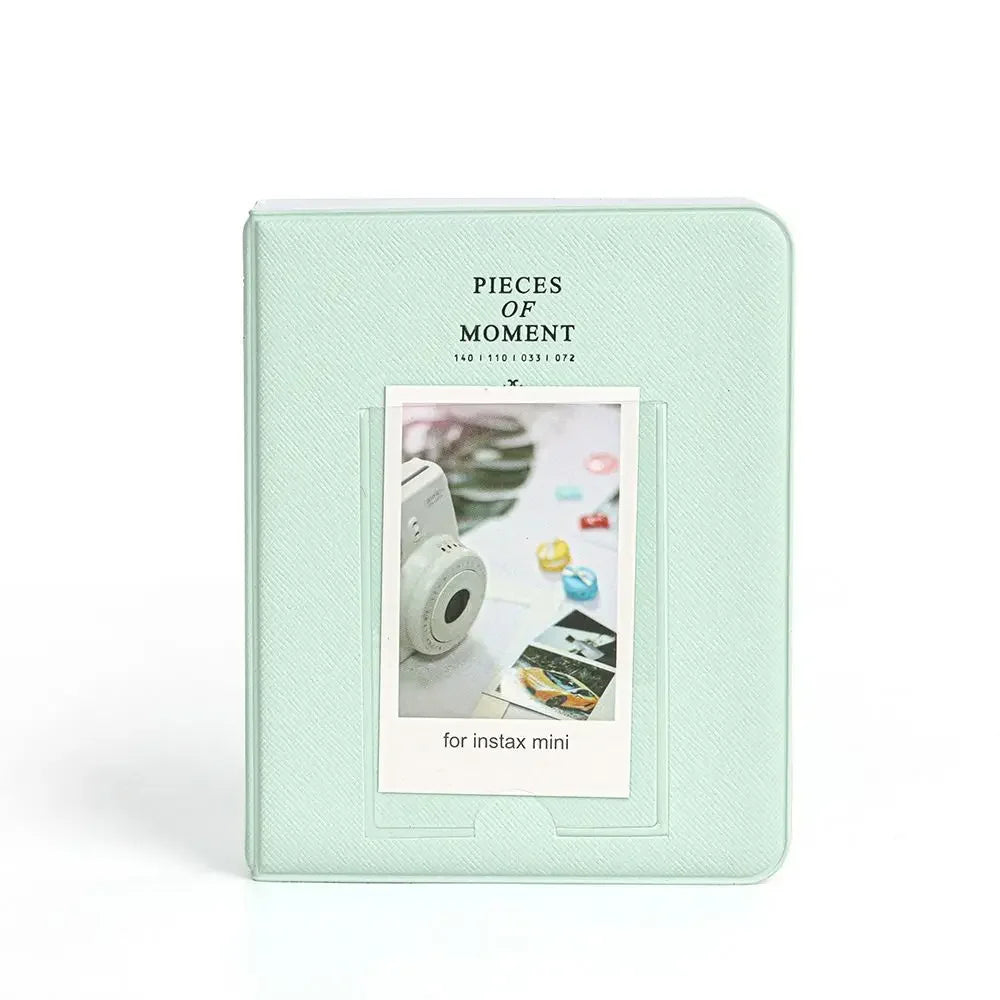 A light mint green album cover titled Pieces of Moment for instant cameras with a clear window displaying photos.
