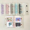 A clear binder with multiple plastic sleeves and magnetic closures for organizing pastel macarons or K-Pop collectibles.