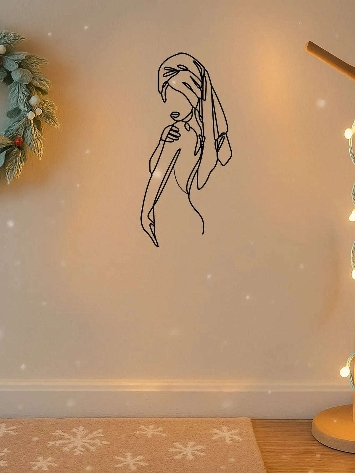 A black line art silhouette of a girl with long hair against a light wall, decorated with soft bokeh lights and falling snowf